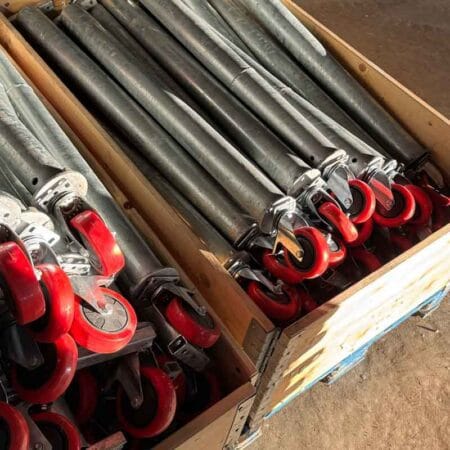 Stödhjul i röd polyuretan monterat på galvaniserat stödben till vägbom för grus- eller asfaltsväg.