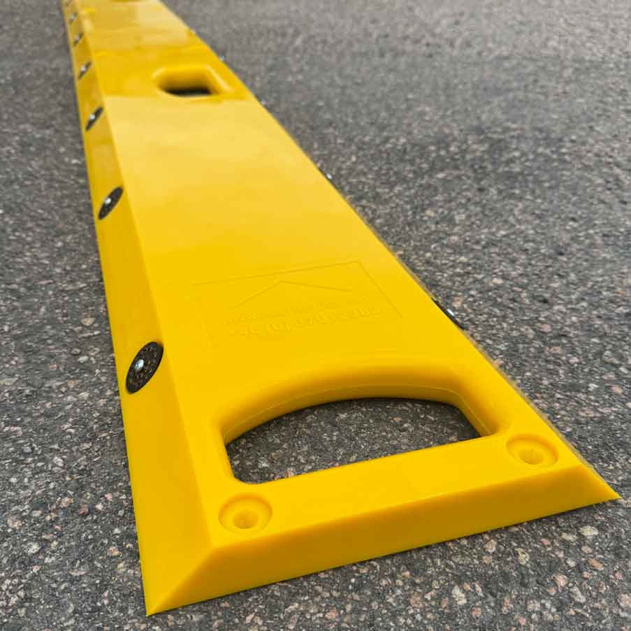 Närbild på gult portabelt farthinder med integrerat bärhandtag och reflexer som hjälper till att sänka hastigheten och öka säkerheten vid tillfälliga trafikmiljöer.