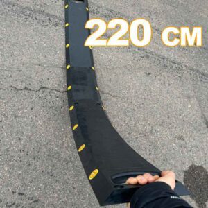 Person håller upp Farthinder Vakna Svart med en hand och visar dess flexibla konstruktion