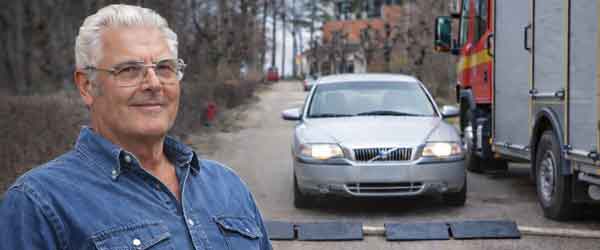 Småländskt kvalitet om oss med min farfar i halvporträtt och texten ”Vi hjälper dig!”, symbol för trygg service och erfarenhet inom trafiksäkerhet.