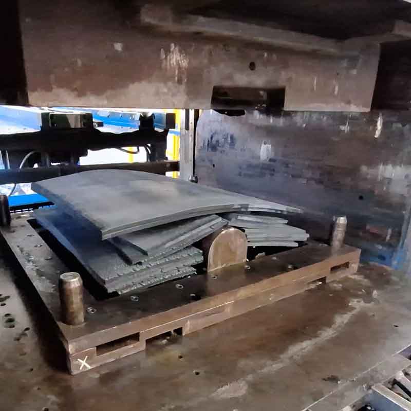 Gummimaterial som formpressas i ett stålverktyg under produktion.