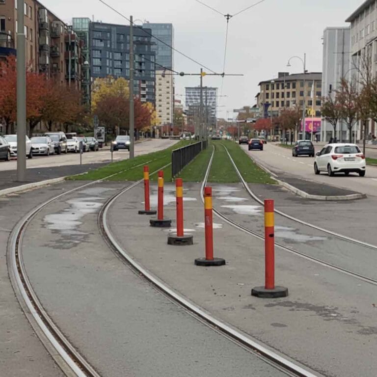 Vägkoner och kantstolpar placerade på stadsgata för att styra trafik och skapa säker avgränsning