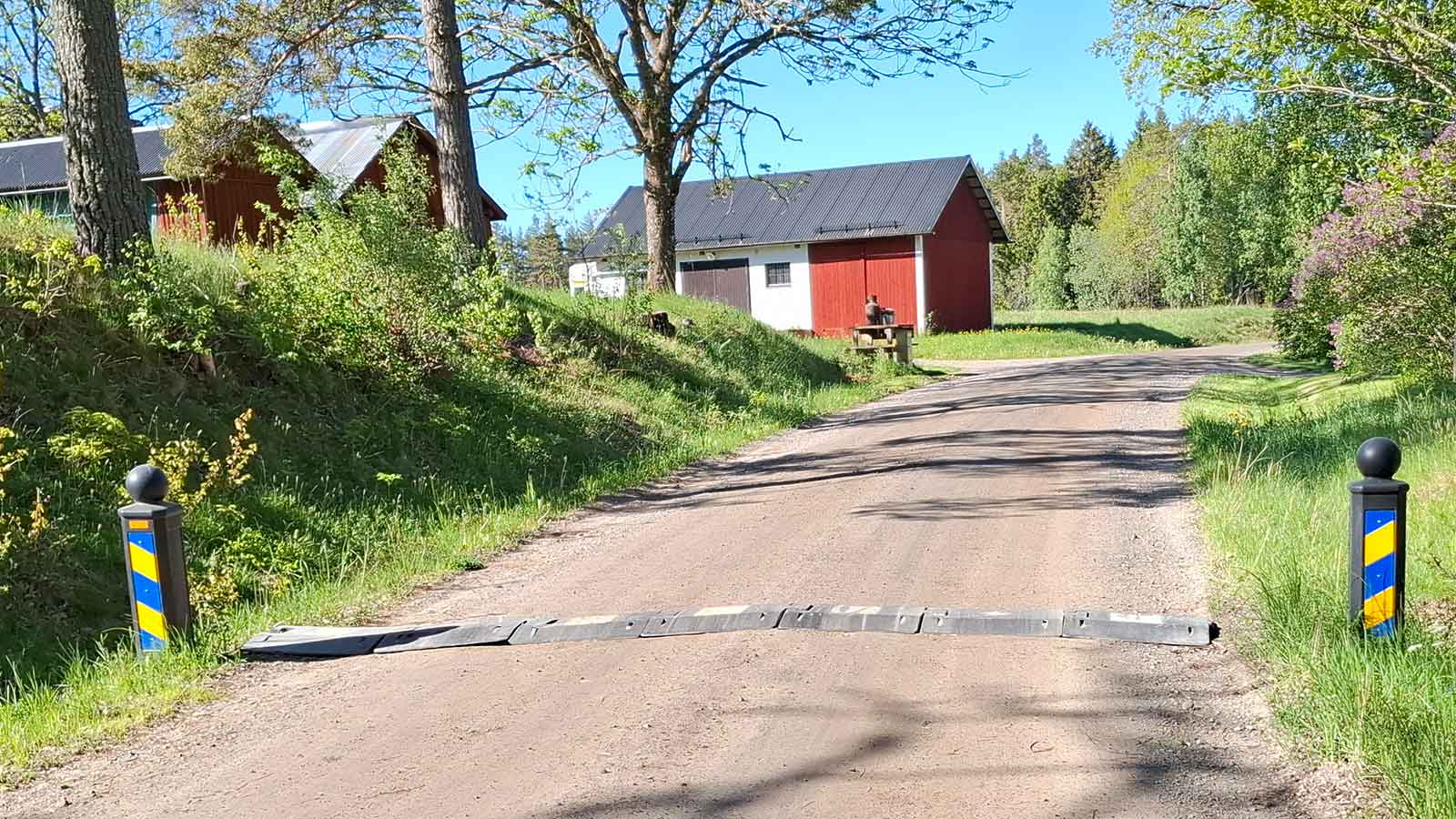 Värnamo farthinder monterat på grusväg i svenskt villaområde med sidomarkeringar och lantlig miljö