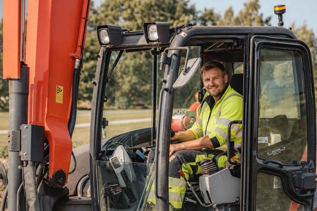 Entreprenör i grävmaskin på bygg- och anläggningsarbetsplats